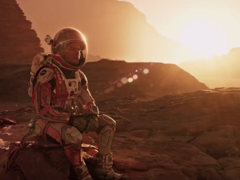 Mark Watney sitting on a rock on Mars
