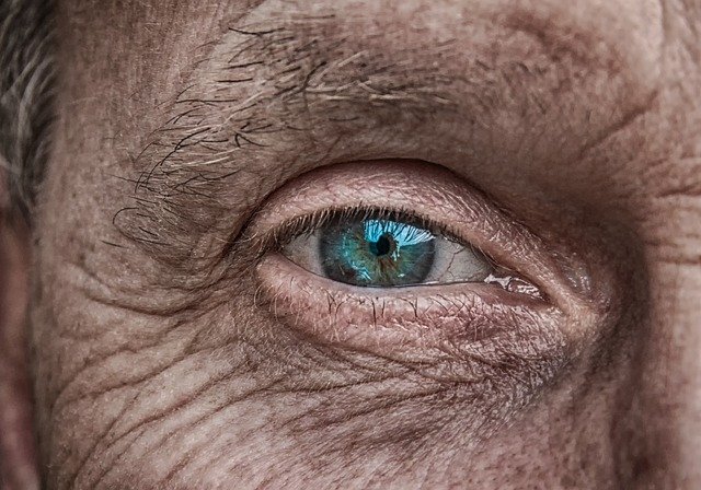 An older man looking right ahead with a blue eye